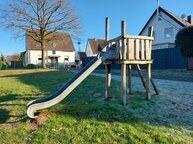 Ein Spielturm mit Rutsche ist zu sehen.